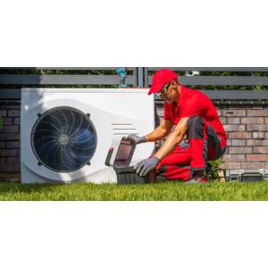 HVAC technician performing maintenance on an outdoor heat pump unit in a residential yard