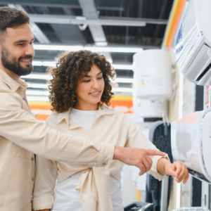 Smiling couple shopping for a new air conditioner and comparing mini split units in a home appliance store