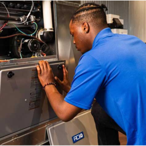 HVAC technician performing furnace and air conditioner installation, inspecting system components for proper setup.