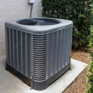 Outdoor split air conditioning condenser unit installed beside a home exterior wall