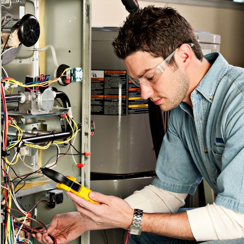 HVAC repairman repairing an electric furnace for a mobile home