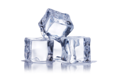 Full and half ice cubes stacked on a reflective surface