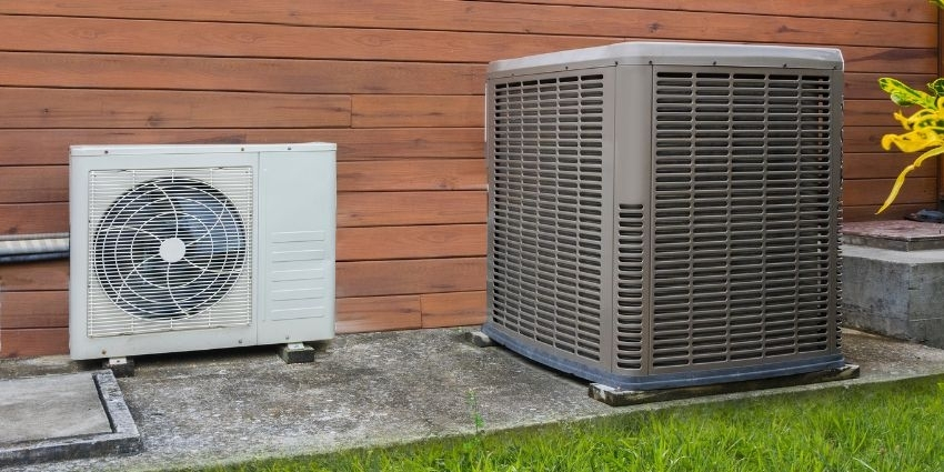 Goodman Heat Pump Condenser vs. Air Conditioner Outdoor Units. Goodman heat pump condenser and air conditioner side by side outside a home.