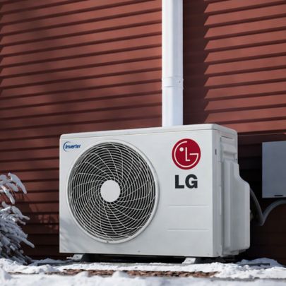 LG mini split outdoor condenser installed outside home with snow showing cold weather heating capability