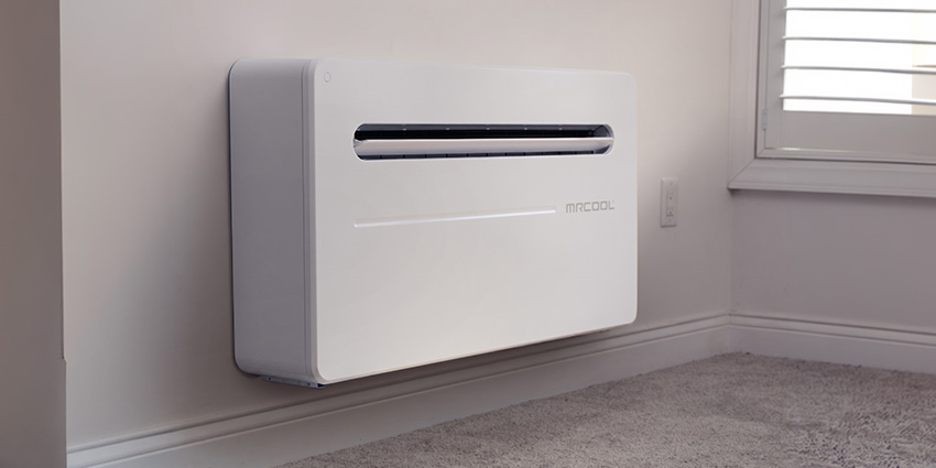 Wall-Mounted Ductless Air Conditioner in Modern Room White wall-mounted ductless air conditioner installed near a window in a modern room for efficient heating and cooling.