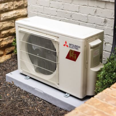 Mitsubishi Electric mini split outdoor condenser installed outside residential home on concrete pad